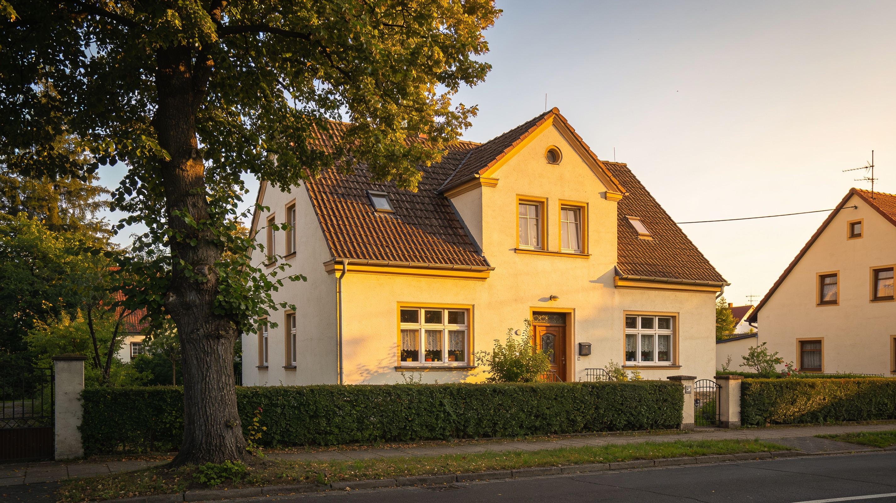 Traditionelles sächsisches Wohnhaus in ruhiger Wohnstraße im warmen Abendlicht